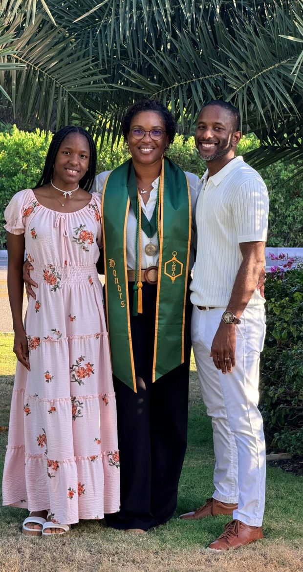 Our family of three on graduation day, with me in a green honors stole in the middle